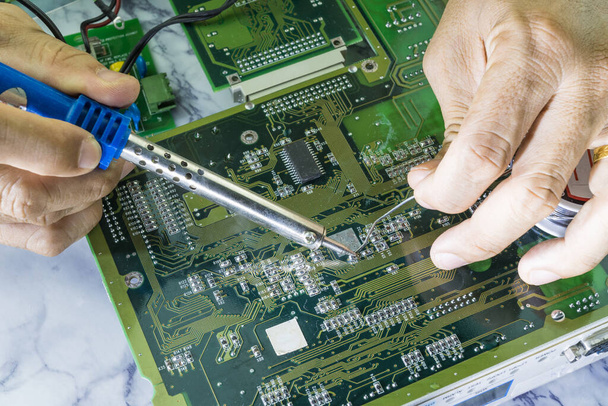 Los técnicos están utilizando un soldador para reparar electrónica de la tecnología de concepto de placa de circuito informático de hardware de circuito informático. - Foto, imagen