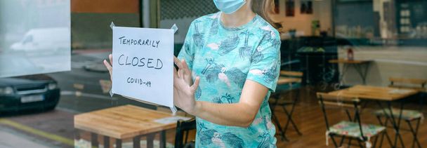 Женщина помещает знак закрытия коронавируса - Фото, изображение