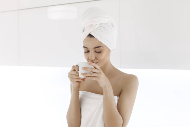 Young woman in towel enjoying coffee at home. - Fotoğraf, Görsel