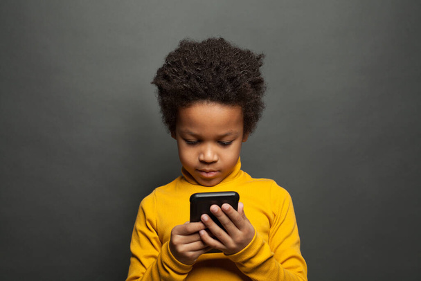 Little black child using smartphone - Foto, imagen