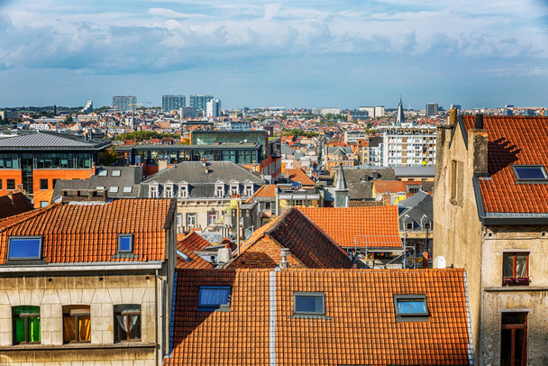 Red brick roofs of an old European city against a bright blue cloudy sky. - 写真・画像