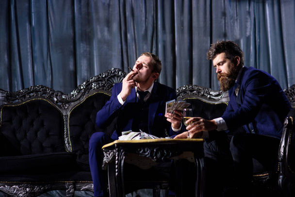 Two gamblers with money smoking and drinking - 写真・画像