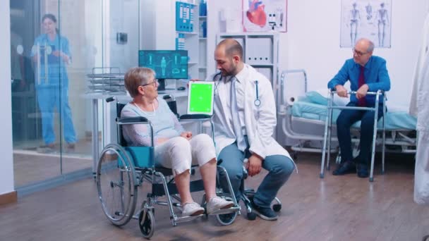 Medico con tablet schermo verde nel centro di riabilitazione - Filmati, video