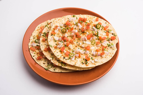 Masala Papad of papadum is een heerlijke Indiase snack gemaakt van geroosterde of gebakken papade gegarneerd met een pittige en pittige ui tomatenmix - Foto, afbeelding