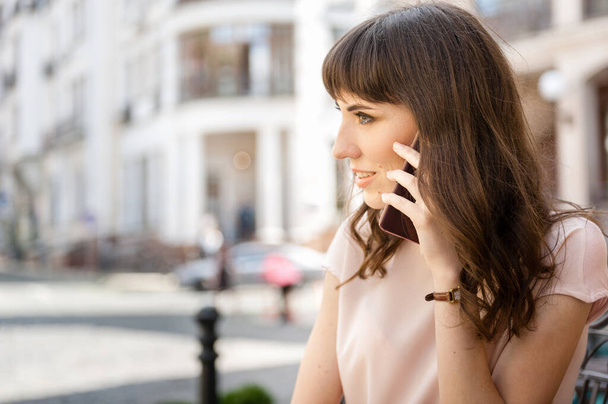 Telefonla konuşan meşgul bir kız, mesaj atmak için boş bir yer var. - Fotoğraf, Görsel