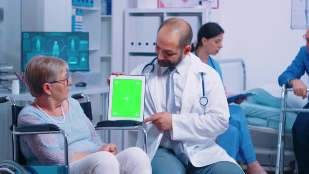 Praktikant držící maketovou tabletu v zotavovacím centru pro starší zdravotně postižené - Záběry, video