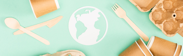 Vue panoramique de vaisselle jetable et signe de terre en papier sur fond vert, concept d'écologie - Photo, image