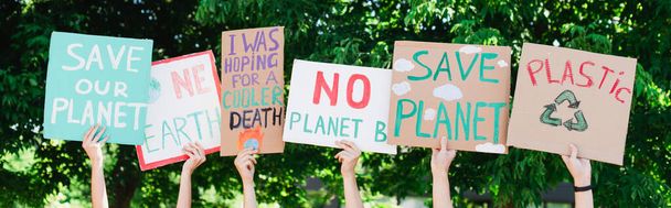Foto panorámica de personas sosteniendo pancartas con salvar nuestro planeta y una tierra escribiendo al aire libre, concepto de ecología - Foto, imagen