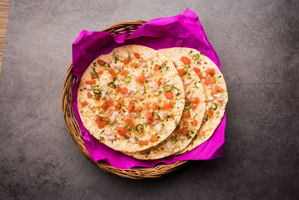 Masala Papad or papadum is a delicious Indian snack made using roasted or fried papad topped with a tangy and spicy onion tomato mix - Fotografie, Obrázek