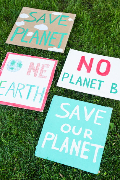 Hohe Blickwinkel auf Plakate ohne Planet b, eine Erde und retten unseren Planeten Schriftzug auf Gras, Ökologie-Konzept - Foto, Bild
