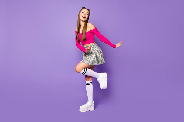 Full size photo of funny crazy lady raise leg dancing star wear pink off-shoulders cropped top plaid skirt long knee socks shoes isolated pastel purple color background - 写真・画像