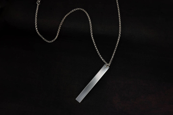 Ezüst ékszer lánc karkötő nyaklánc elszigetelt fekete alapon gravírozott lemez - Fotó, kép