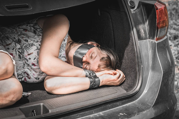  Женщина со связанными руками внутри багажника автомобиля - похищение - Фото, изображение