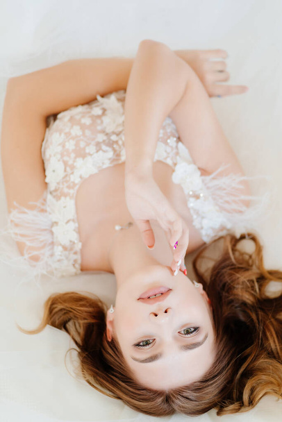 view top. bride in white dress lying in bed. - Fotoğraf, Görsel