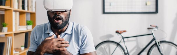 Panoráma felvétel izgatott afro-amerikai üzletember vr headset az irodában  - Fotó, kép