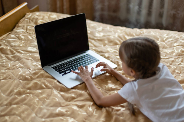 educación, tiempo libre, tecnología y concepto de Internet - niña estudiante con ordenador portátil en casa - Foto, Imagen