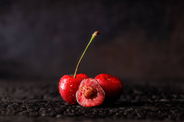 Group of cherry on a dark wood background or table. Juicy fresh cherry berries. Close up of a group of fruit - Foto, afbeelding
