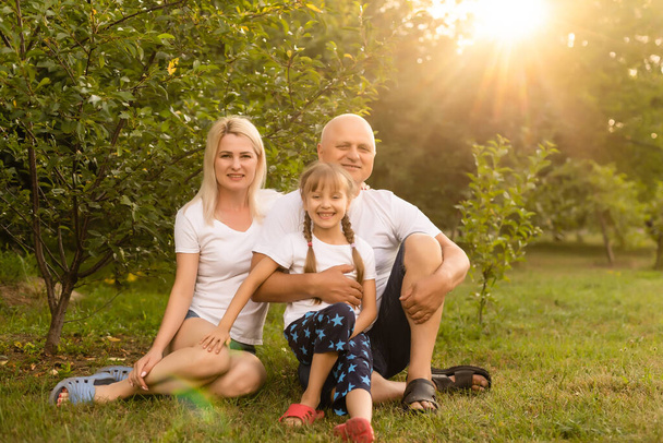 Portrait of cheerful extended family sitting in the park - Фото, зображення