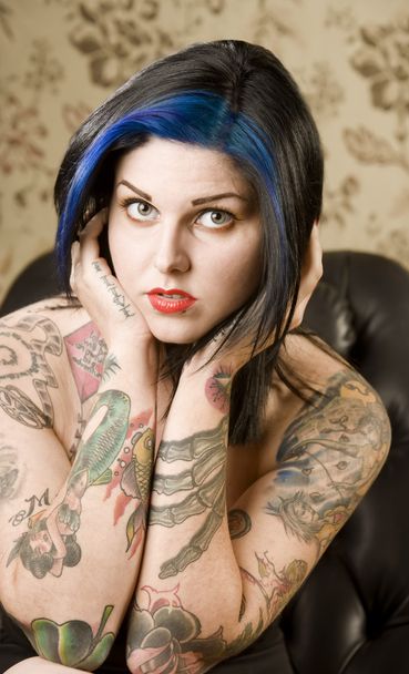 Pretty Woman with Tattoos in a Leather Chair - Zdjęcie, obraz