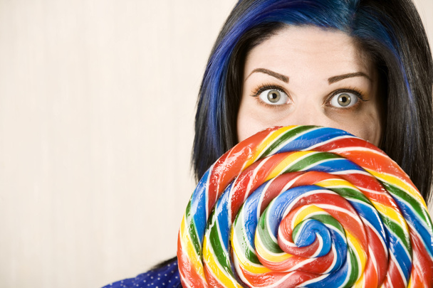 Pretty woman behind a lollipop - 写真・画像