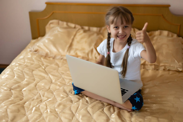 eğitim, boş zaman, teknoloji ve internet konsepti - evde dizüstü bilgisayarı olan küçük kız öğrenci - Fotoğraf, Görsel