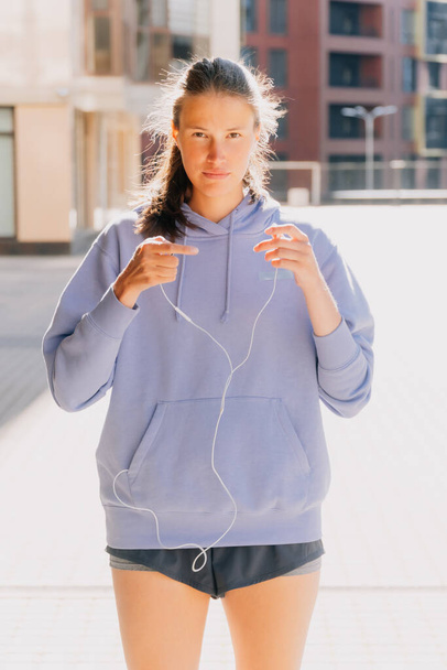 Young stylish girl listens to audio recording with headphones. Concept of online training during training. - Foto, Imagem