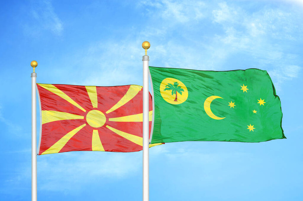 Pohjois-Makedonia ja Cocos Keeling saaret kaksi lippua lipputangot ja sininen pilvinen taivas tausta - Valokuva, kuva