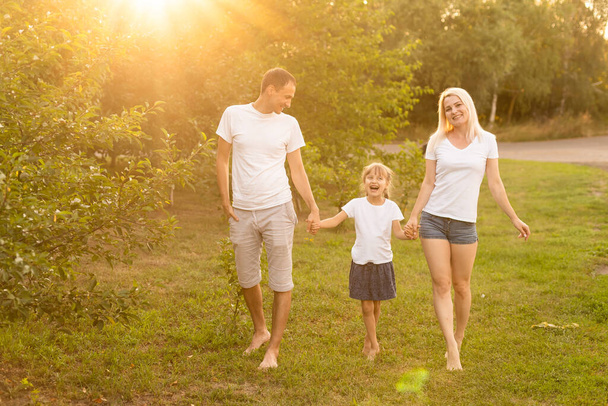 Szczęśliwa rodzina cieszy się w parku na słoneczny dzień - Zdjęcie, obraz
