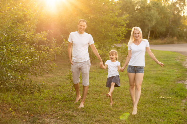 Szczęśliwa rodzina cieszy się w parku na słoneczny dzień - Zdjęcie, obraz