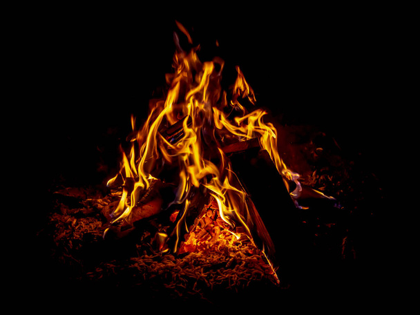 Яркий горящий огонь на черном фоне - Фото, изображение