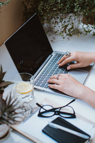 Vrouwen handen op laptop toetsenbord, gezellige werkplek - Foto, afbeelding