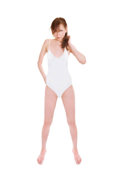 Attractive young woman wearing a white bathing suit, full length portrait isolated in front of white studio background - Foto, afbeelding