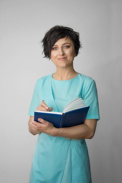 female medical professional holding a notepad for writing - Foto, imagen