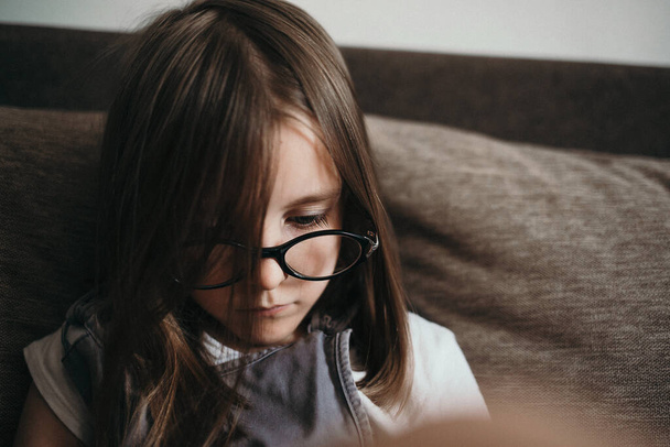 Una chica ve una lección en casa en una tableta
 - Foto, Imagen
