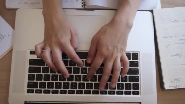Top view of a table as female hands typing on a laptop. - Materiał filmowy, wideo