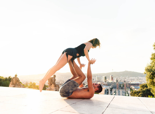 Beautiful man and two women doing acroyoga in the city - Fotoğraf, Görsel