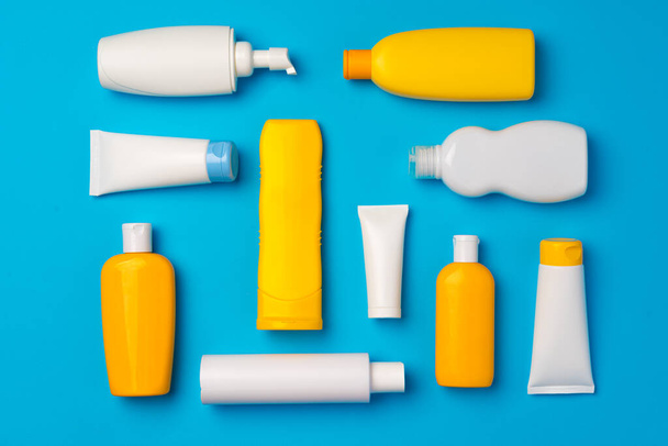 Bottles of sunscreen cream on blue background - Foto, immagini