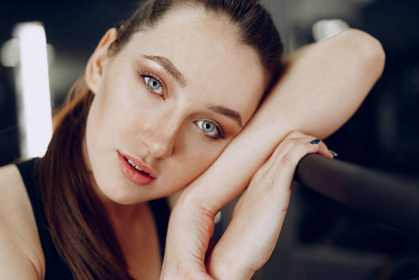 Brunette young woman sitting tired in a gym after workout - Фото, зображення