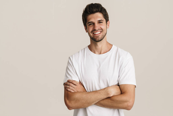 Portrait of cheerful handsome man smiling and looking at camera isolated over white background - Photo, Image