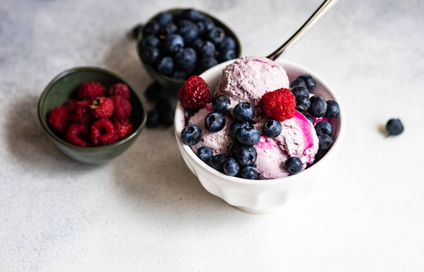 Fruit summer ice cream dessert with fresh organic berries of blueberry served in bowl on stone background with copy space - Fotoğraf, Görsel