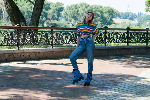 Привлекательная девушка-подросток на роликовых коньках в солнечный летний день позирует в парке - Фото, изображение
