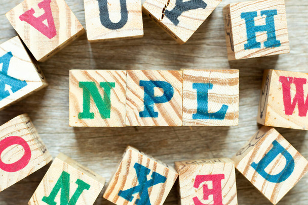 Blocco lettere alfabeto in parola NPL (Abbreviazione di Non Performing Loan, Non-Patent Literature) con un altro su sfondo legno - Foto, immagini