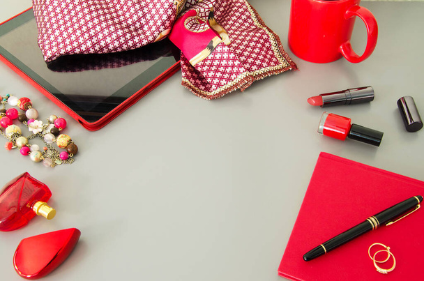 Donna desktop moderno con accessori rossi: tablet, latticini, cosmetici, penna, tazza di caffè.Copyspace. - Foto, immagini