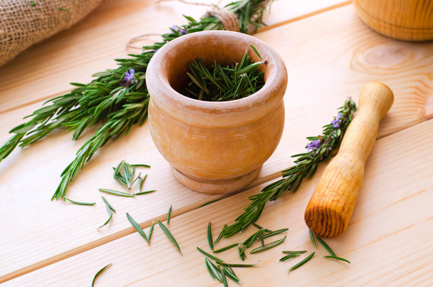 Fresh garden rosemary with old wooden mortal and pestle - Photo, Image