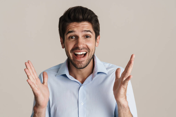 Portrait of excited handsome man expressing surprise on camera isolated over white background - Φωτογραφία, εικόνα