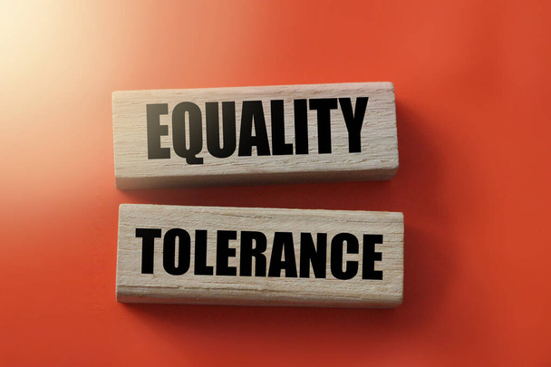 gelijkheid en tolerantie woorden op houten blokken op rood. - Foto, afbeelding
