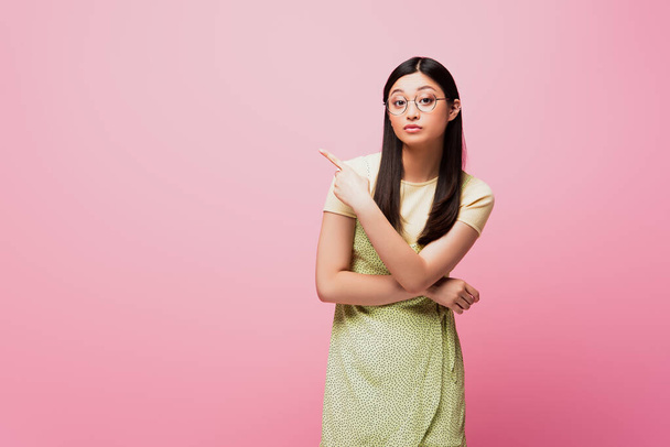 young asian woman in glasses pointing with finger isolated on pink  - Foto, Imagem