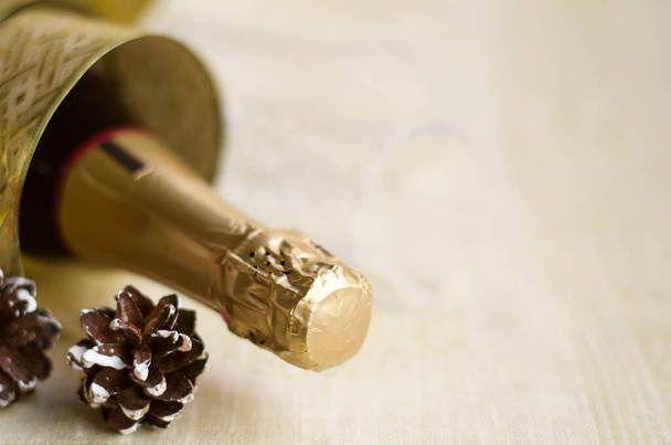 Бутылка шампанского с золотой глянцевой лентой и натуральным конусом. Счастливого Нового Года! - Фото, изображение