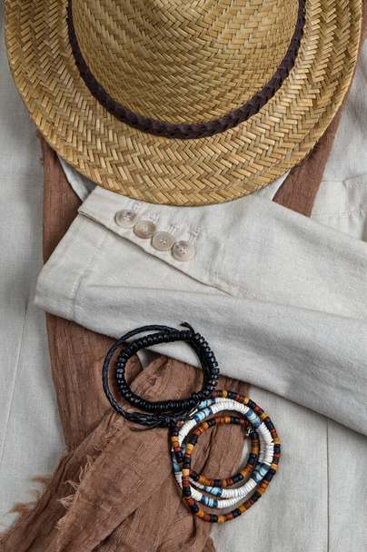 Sombrero de paja, bufanda, abrigo de lino clásico y pulseras. Tema elegante atuendo de verano - Foto, imagen