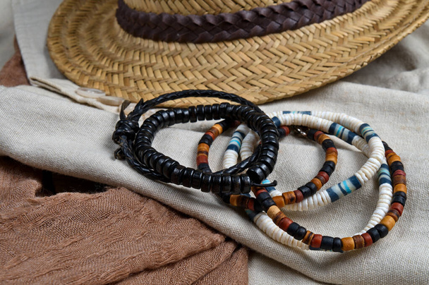 Sombrero de paja, bufanda, abrigo de lino clásico y pulseras. Tema elegante atuendo de verano - Foto, imagen